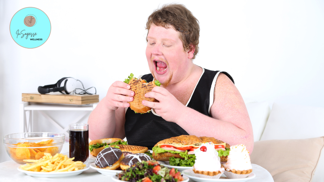 Person enjoying a large meal with various foods on a table, highlighting the importance of mindful eating guidance from a Wellness Coach.